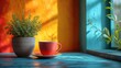  a cup and saucer sitting on a table next to a potted plant on a window sill in front of a yellow and orange wall with blue trim.