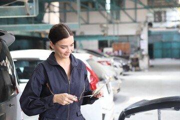 Auto mechanic working in garage. Repair service. Worker mechanics in uniform are working in auto service with lifted vehicle. Car repair maintenance.