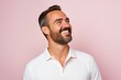 © Asier - Handsome man with beard and mustache laughing on a pink background