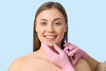 Poster - Beautiful woman receiving injection on blue background, closeup