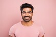 © Inigo - Portrait of a handsome young man smiling at the camera on a pink background