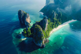 aerial view of beach is a crescent of white sand, framed by towering limestone cliffs covered in lush green vegetation