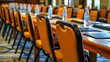Orange chairs and tables in a row in a conference hall or seminar room
