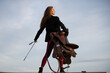 © Volodymyr - Sexy cowgirl hold saddle and whip. Equestrienne horsewoman. American cowboy style. Cowgirl woman in countryside. Horsewoman jockey. Jockey Equestrienne equipment. Horse riding concept.