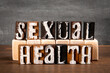 SEXUAL HEALTH Concept. Alphabet blocks on wood texture background