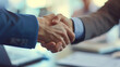 © SashaMagic - A successful business partnership handshake in an office.