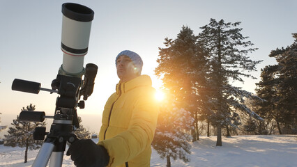 Amateur astronomer looking at the Sun through a telescope with special solar filter.