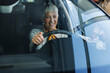 © Westend61 - Happy woman examining car in showroom