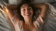 © john - a very happy young woman lying on her bed smiling