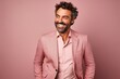 © Iigo - Handsome middle aged man in a pink suit posing on a pink background.