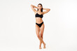 © GVS - Full length portrait of perfect young woman with sporty body in black underwear posing on white