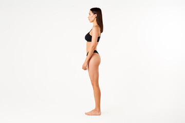 Wall Mural - Profile view of full length portrait of beautiful sensual slim woman in black underwear