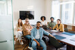© Vadim Pastuh - A cheerful and relaxed team sits casually around a conference table in a bright office, representing a comfortable work atmosphere where open communication and camaraderie are clearly valued