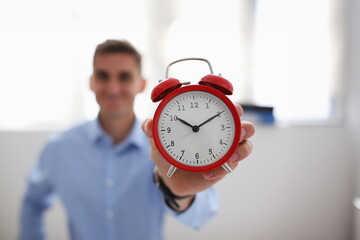 Wall Mural - Smiling business woman holding in hand on the alarm