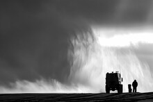 A Lone Truck Navigates Through A Foggy, Monochromatic Landscape With An Expansive Sky And Cloud-filled Horizon