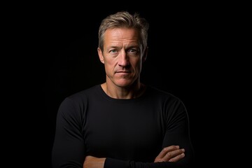 Wall Mural - Portrait of a middle aged man in a black sweater on a black background