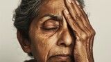 Fototapeta  - An elderly person with closed eyes resting their head on their hand conveying a sense of fatigue or contemplation.