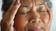 An elderly person with closed eyes resting their head on their hand showing signs of relaxation or contemplation.