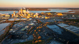 Fototapeta  - Early morning light bathes a paper mill in Brunswick, Georgia, with storage and industrial activity.