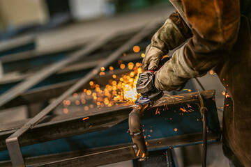 Wall Mural - Factory worker grinding a metal,close up