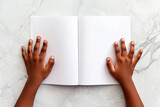 Fototapeta Tęcza - Child's hands with blank book on light background