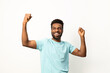 Portrait of a happy African American man smiling and raising his fists in victory or celebration against a white background.