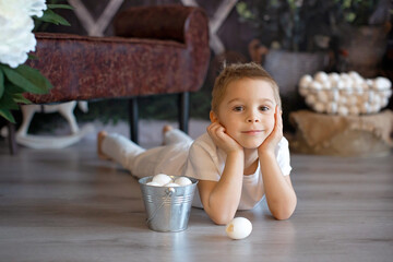 Wall Mural - Sweet toddler child, cute boy playing with Easter eggs, Easter decoration