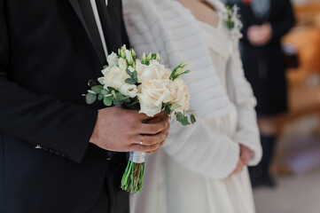 Wall Mural - A beautiful wedding bouquet in the hands of the groom. Bouquet with white roses in the hands of the groom