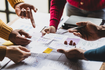 UX, UI designers collaborate to design user interfaces for smartphone apps based on user experience. Colleagues meeting, program designers brainstorm to discuss designing mobile applications.