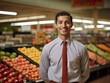 © Veronika - A cheerful salesman standing in a vibrant grocery store, wearing a welcoming smile as he looks directly at the camera, with neatly organized shelves of products in the background.