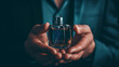 Close-up of a man's hands and a bottle of perfume.