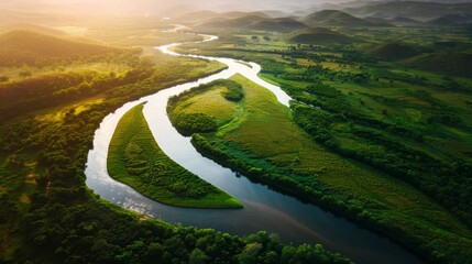 Aerial view of a meandering river through vibrant green wetlands at sunset