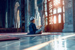 Religious Muslim little boy reading Koran Bible book in mosque