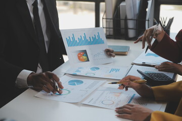 Financial analysts analyze business financial reports on a digital tablet planning investment project during a discussion at a meeting of corporate showing the results of their successful teamwork.