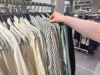 a woman chooses a shirt in a  clothing store