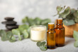 © Avocado_studio - Eucalyptus essential oil in a glass bottle with green eucalyptus leaves on a textured wooden background. Aromatherapy concept. Spa. Natural organic ingredients for cosmetics and body care.Copy space