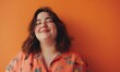 Cute plump smiling girl on an orange background.