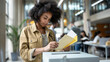 © colnihko - Young African American woman with curly hair casts her ballot at voting station