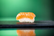 Close up of one piece of salmon nigiri with green background