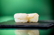 Close up of two pieces of cod nigiri with green background