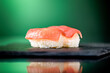 Close up of two pieces of tuna nigiri with green background