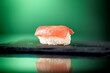 Close up of one piece of tuna nigiri with green background