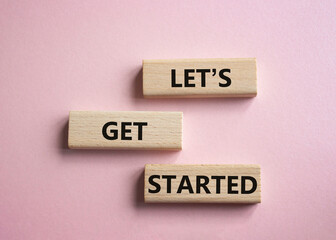 Wall Mural - lets get started symbol. concept words lets get started on wooden blocks. beautiful pink background.