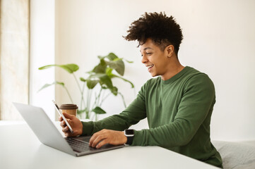 Wall Mural - Happy african american guy entrepreneur working at cafe