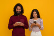 © Prostock-studio - Cheerful young eastern couple with smartphones in hands