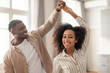 © Prostock-studio - Happy African American married couple enjoying romantic weekend dance indoors