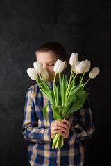 Wall Mural - The boy is holding a bouquet of white tulips