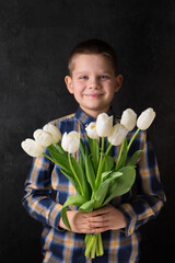 Wall Mural - The boy is holding a bouquet of white tulips