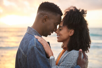 Wall Mural - Loving multiethnic couple with closed eyes standing on a beach at dusk