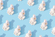 © SLV - Pattern made with 3d porcelain white house with chimney shape lanterns on bright blue background. Creative minimal art. Flat lay. Copy space. Minimal composition. Minimal wallpaper
